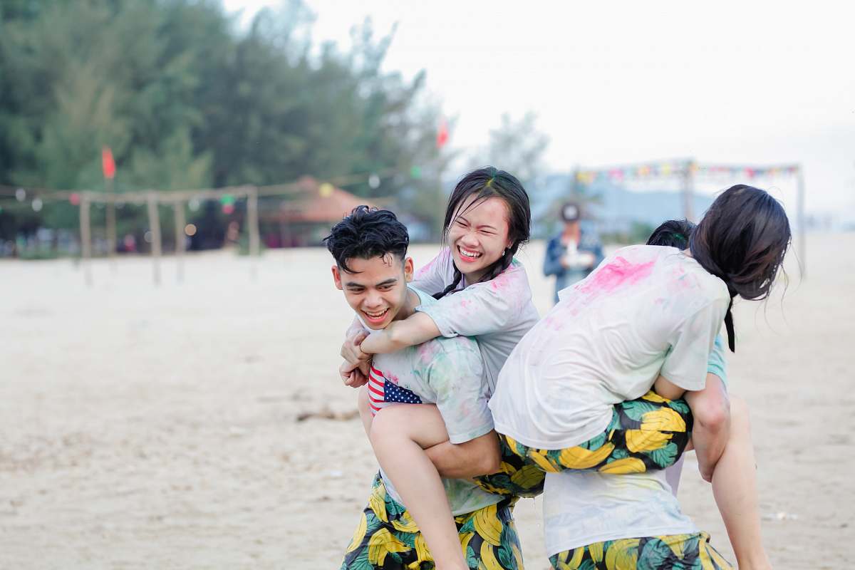 person two man carrying girls on seashore people