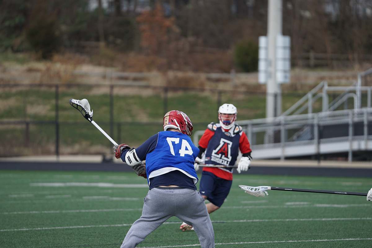 clothing two men playing lacrosse on field apparel