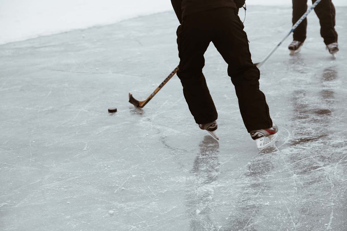 person two persons playing hockey on ice field sport