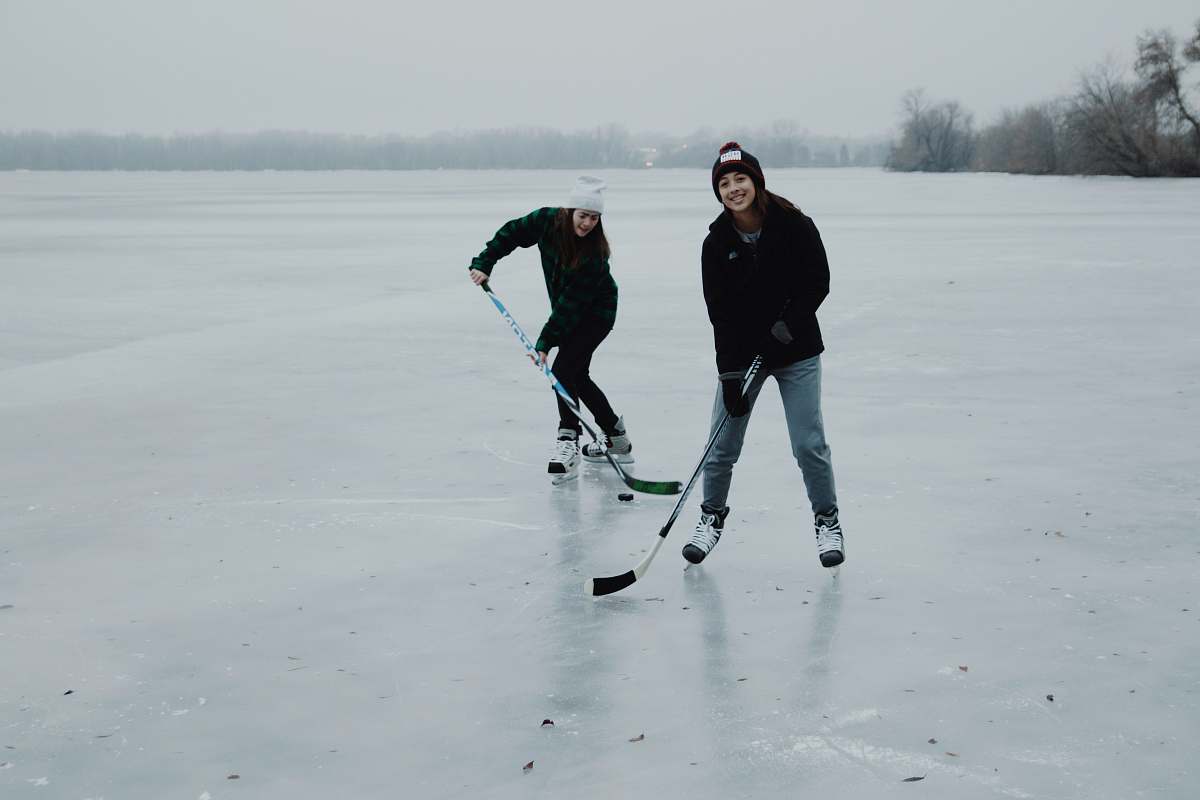 person two women playing ice hockey shoe