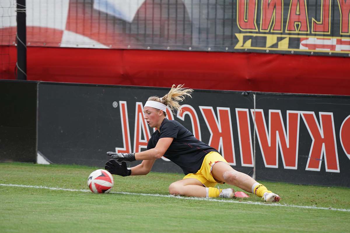 person woman catching red and white soccer ball on focus photo people