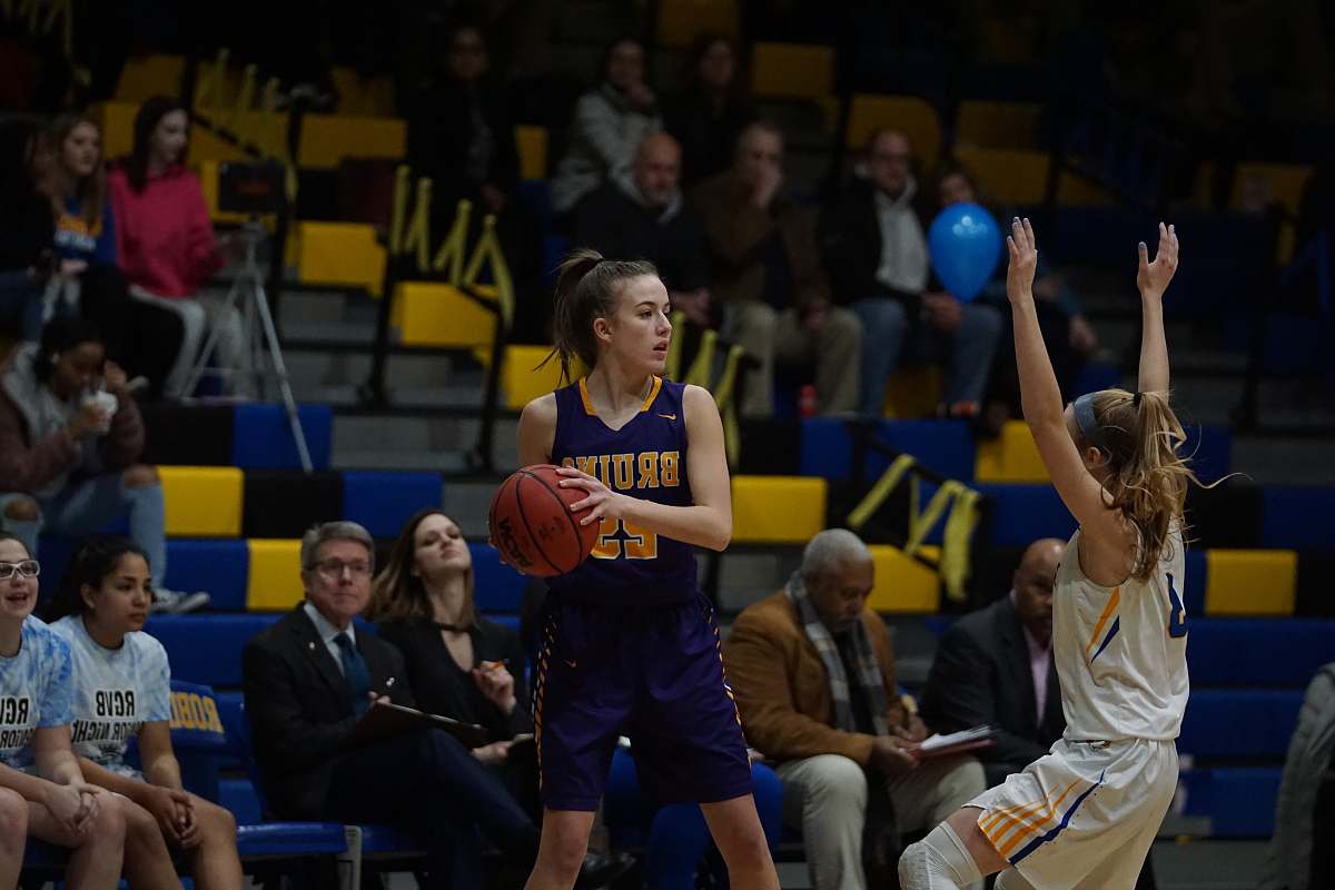 person woman in blue and yellow basketball jersey holding basketball in court people