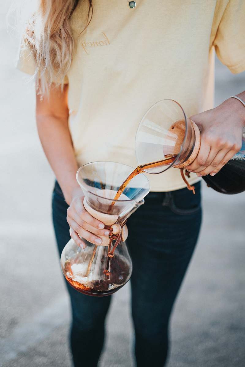 person woman pouring liquid on jar people
