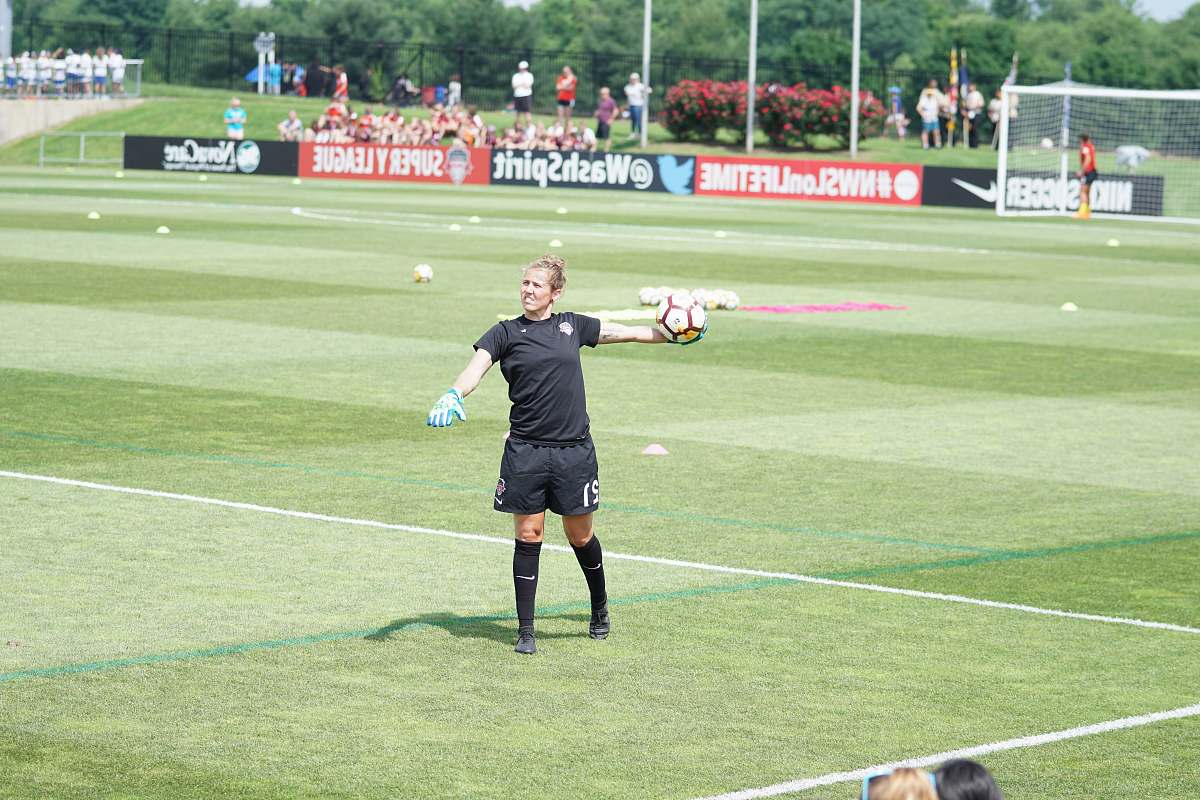 person woman throwing soccer ball on soccer field people