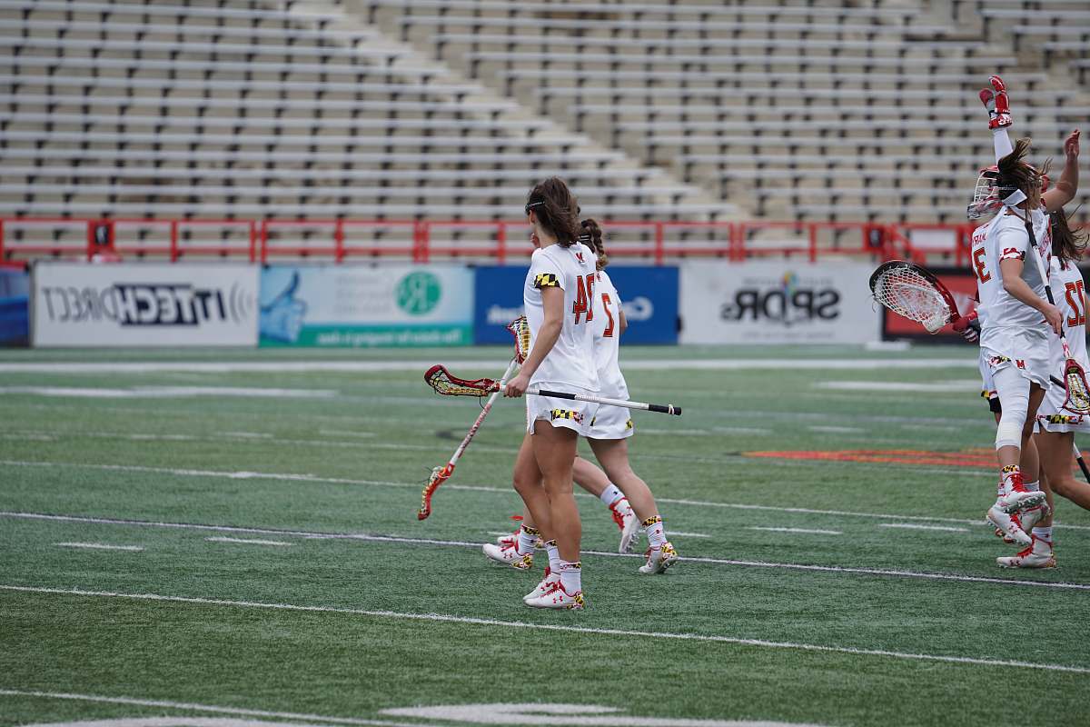 person women playing lacrosse at the field people