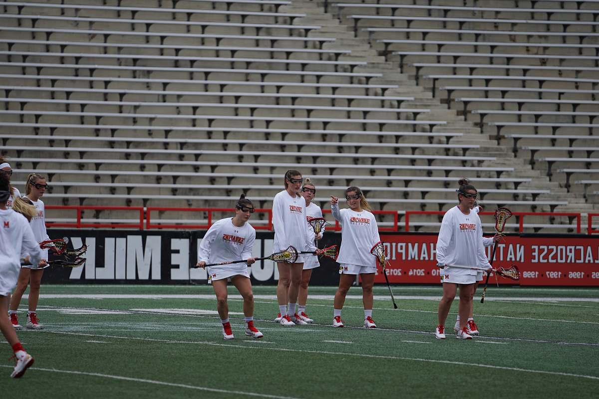 person women playing lacrosse game field