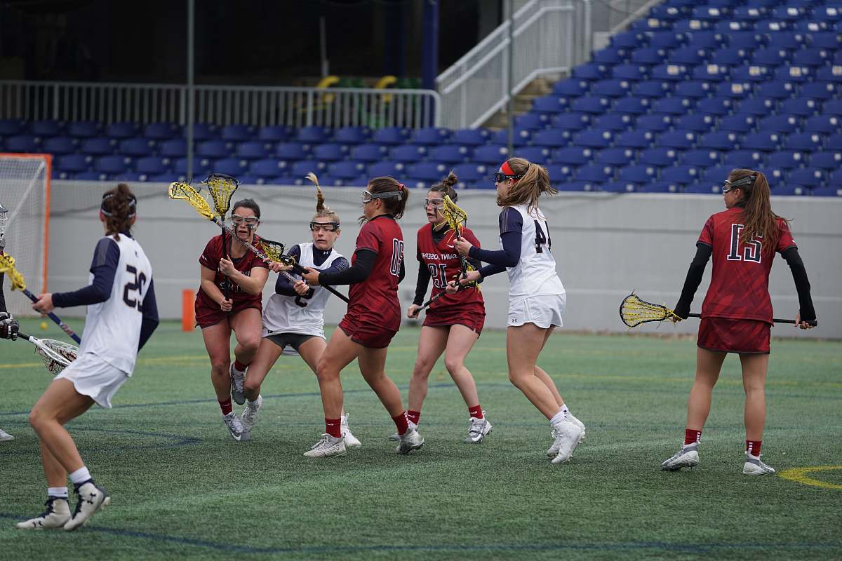person women playing lacrosse on field racket