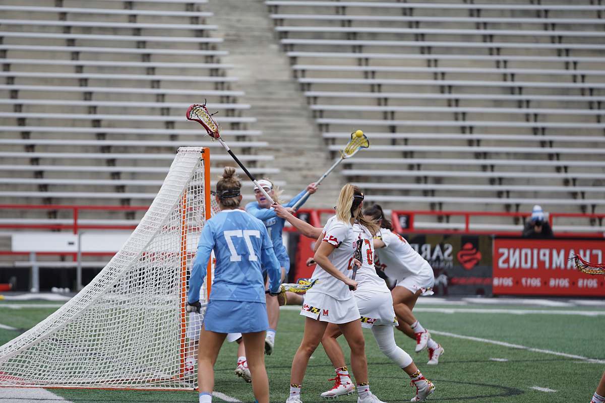 person women playing lacrosse outside apparel