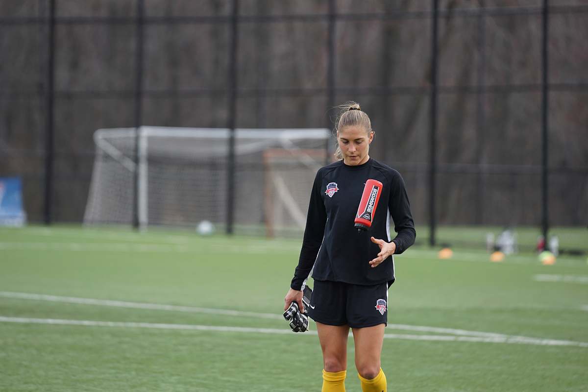 person women standing on soccer field people