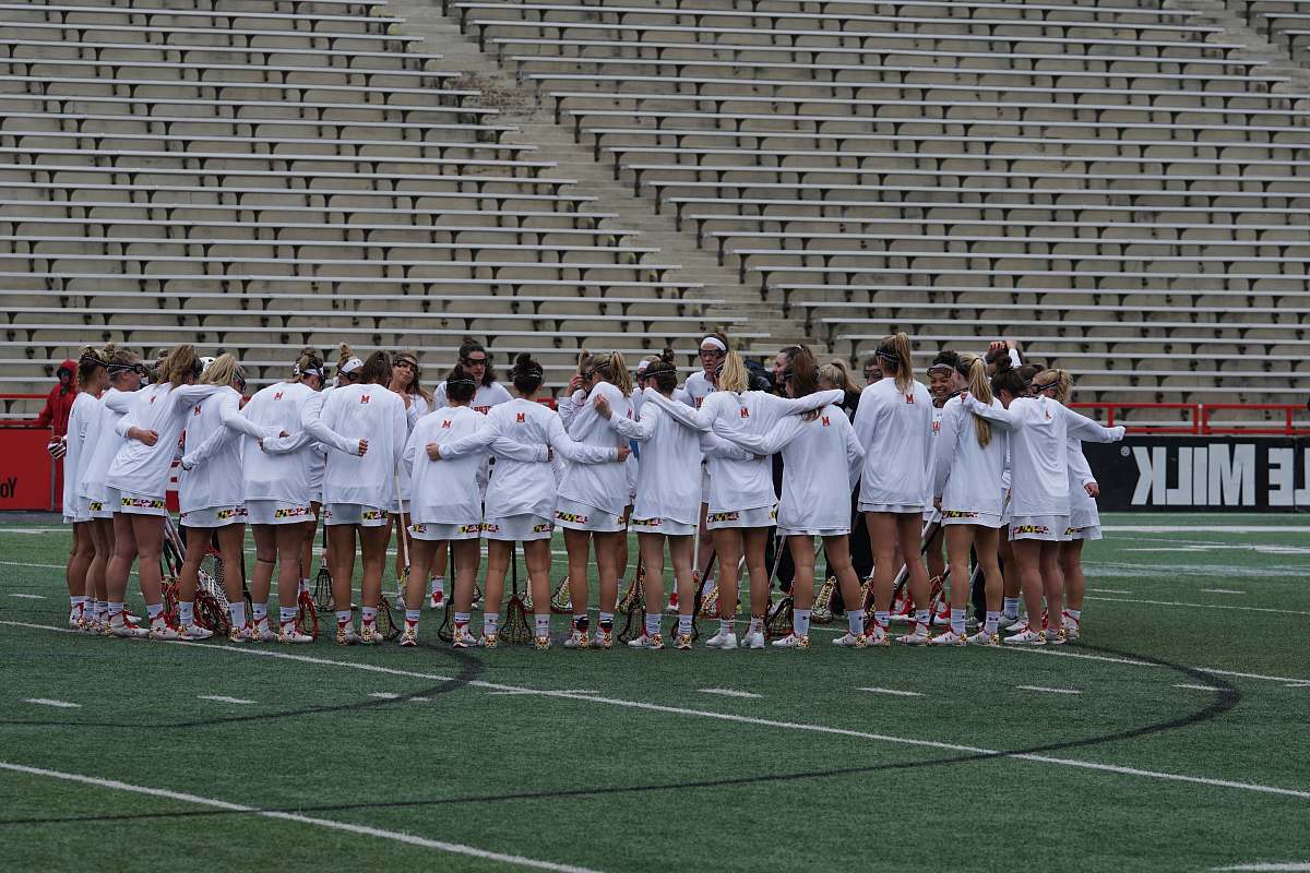 person women wearing white long-sleeved shirt huddling outside field