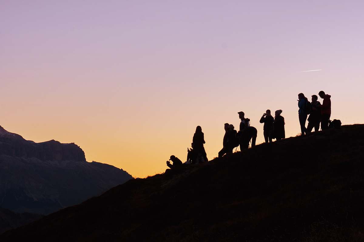 sunset silhouette of group of people on hill silhouette