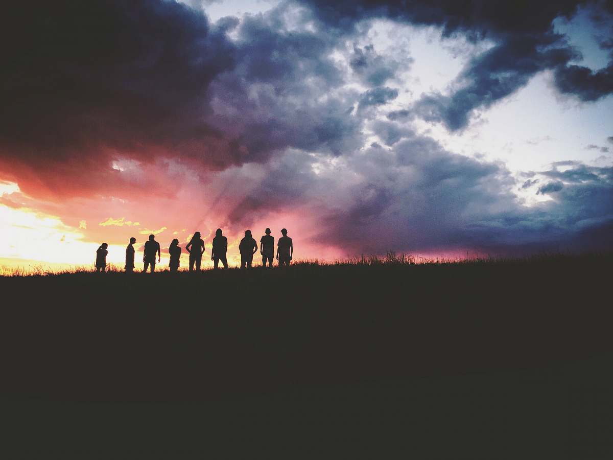 outdoors silhouette of nine persons standing on the hill sky
