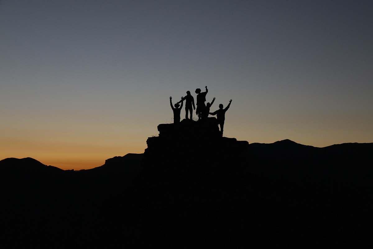 sunset silhouette of people standing on highland during golden hours outdoors