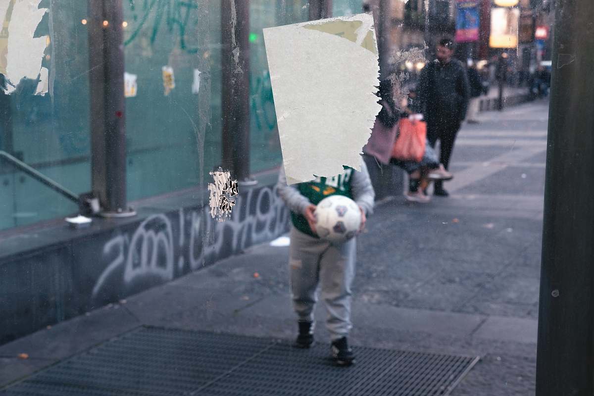 human boy holding white soccer ball pedestrian