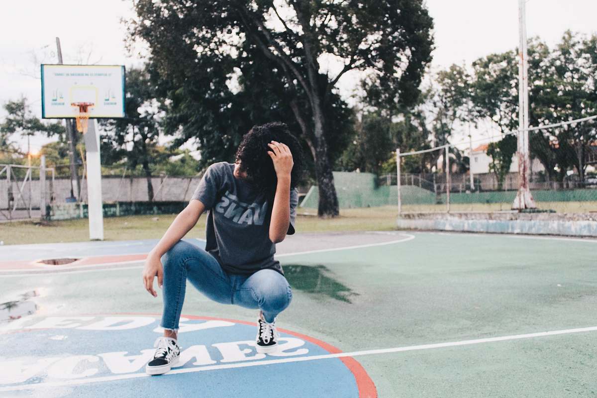 human crouching woman wearing gray t-shirt on basketball court team sport