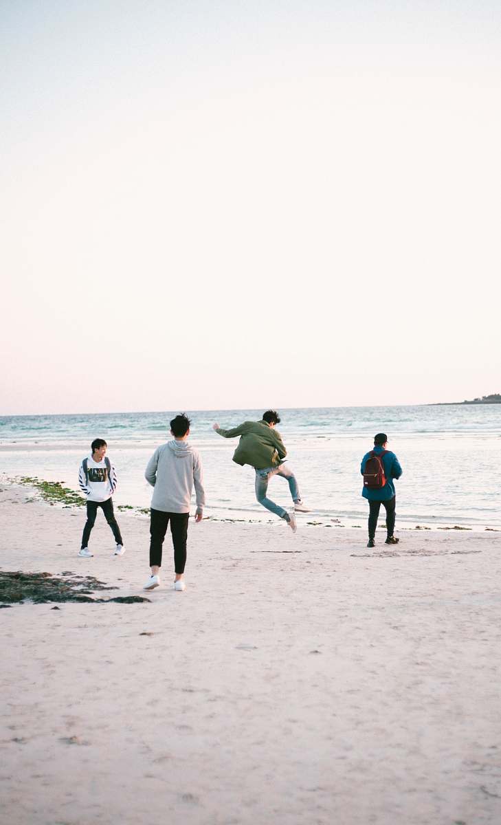 human four persons near shore at daytime apparel