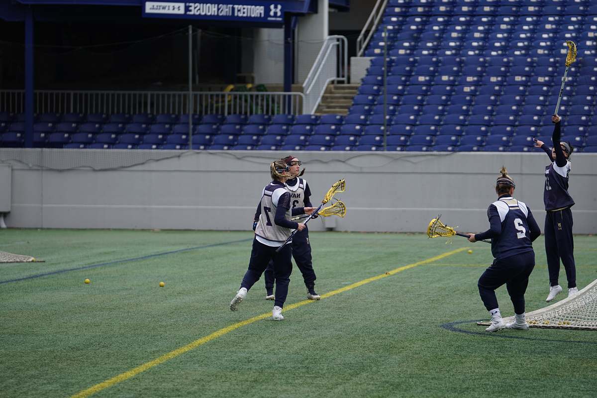 human four women playing lacrosse during daytime apparel