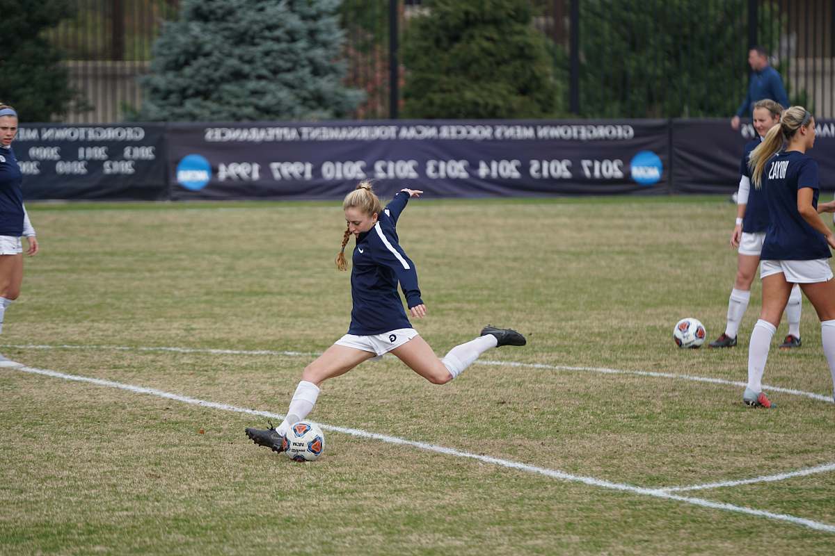 soccer girl trying to kick soccer ball during daytime human