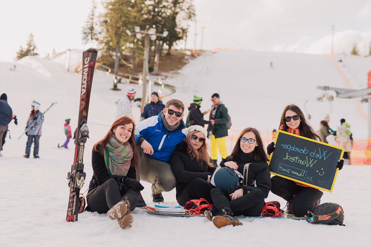 human group of people sitting on snow taking photo people