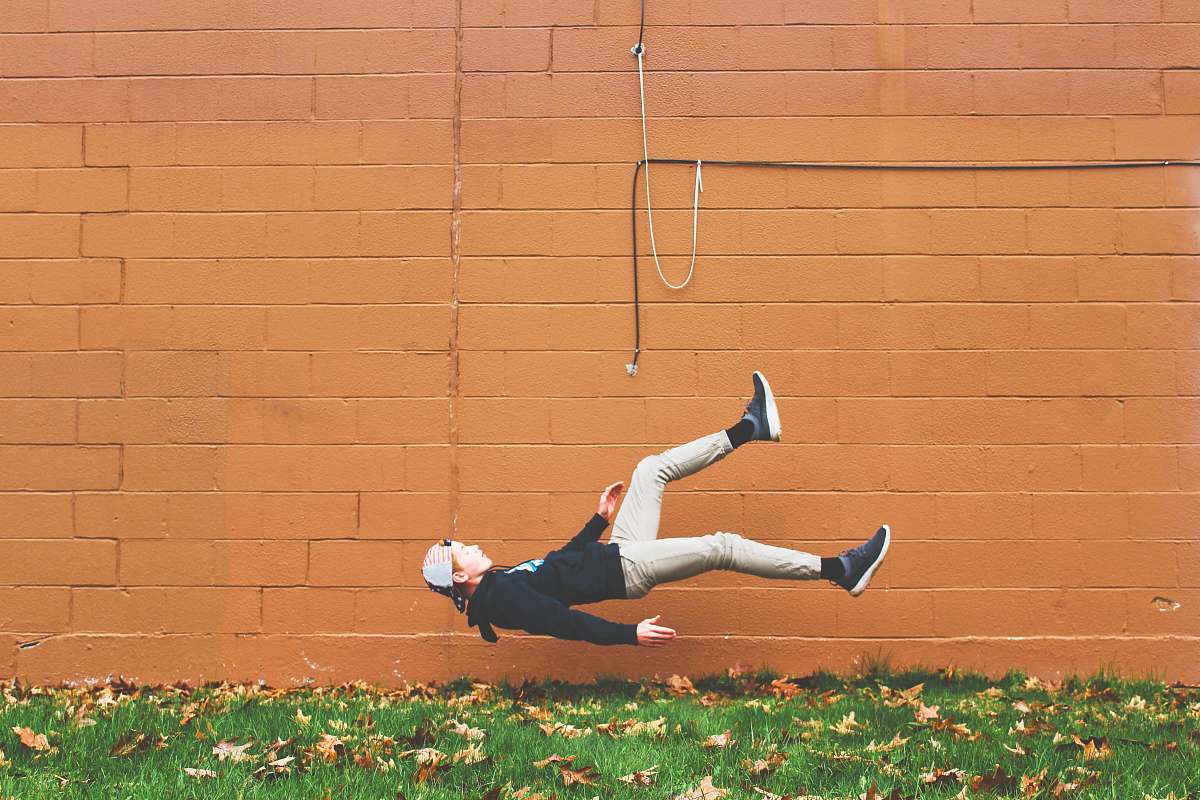 human man falling on ground beside wall clothing