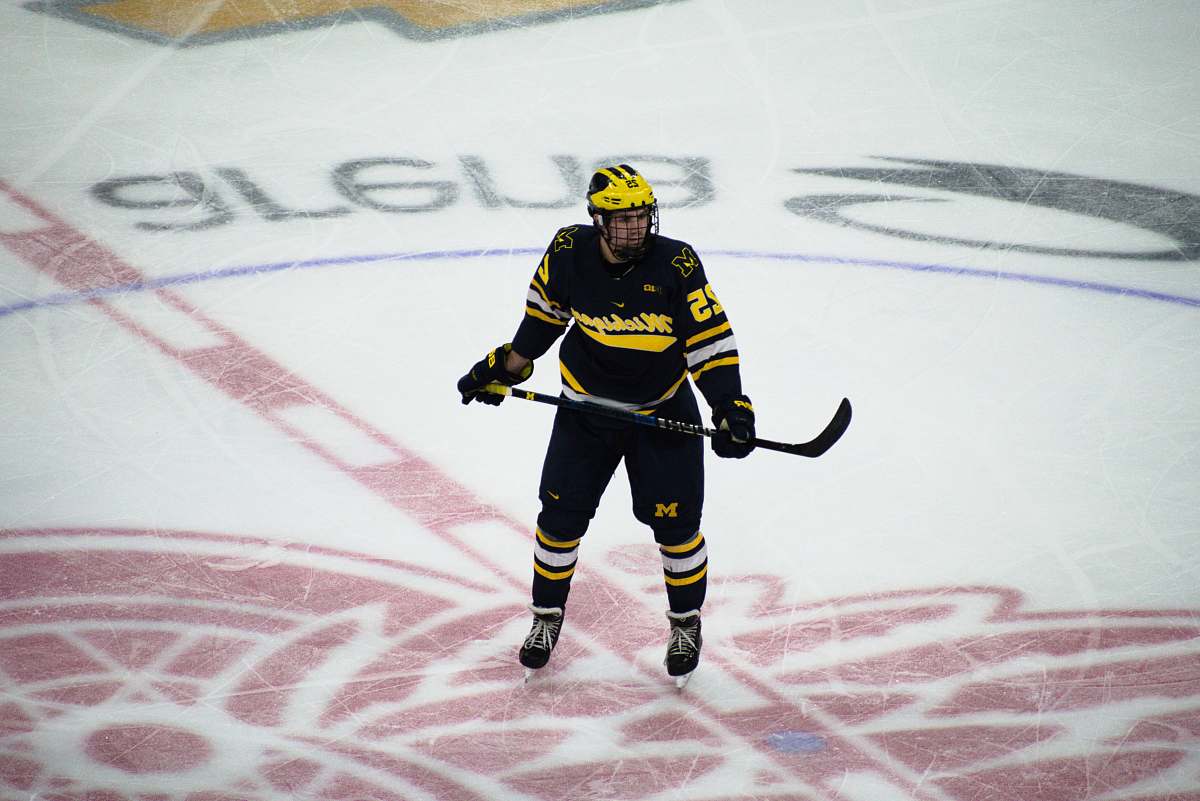 human man in hockey gear holding stick on ice rink sport