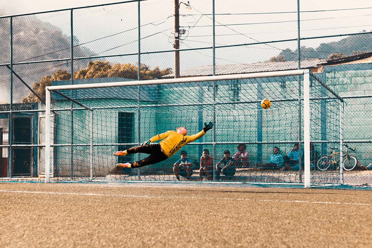 sport man jump about to hold ball near net football