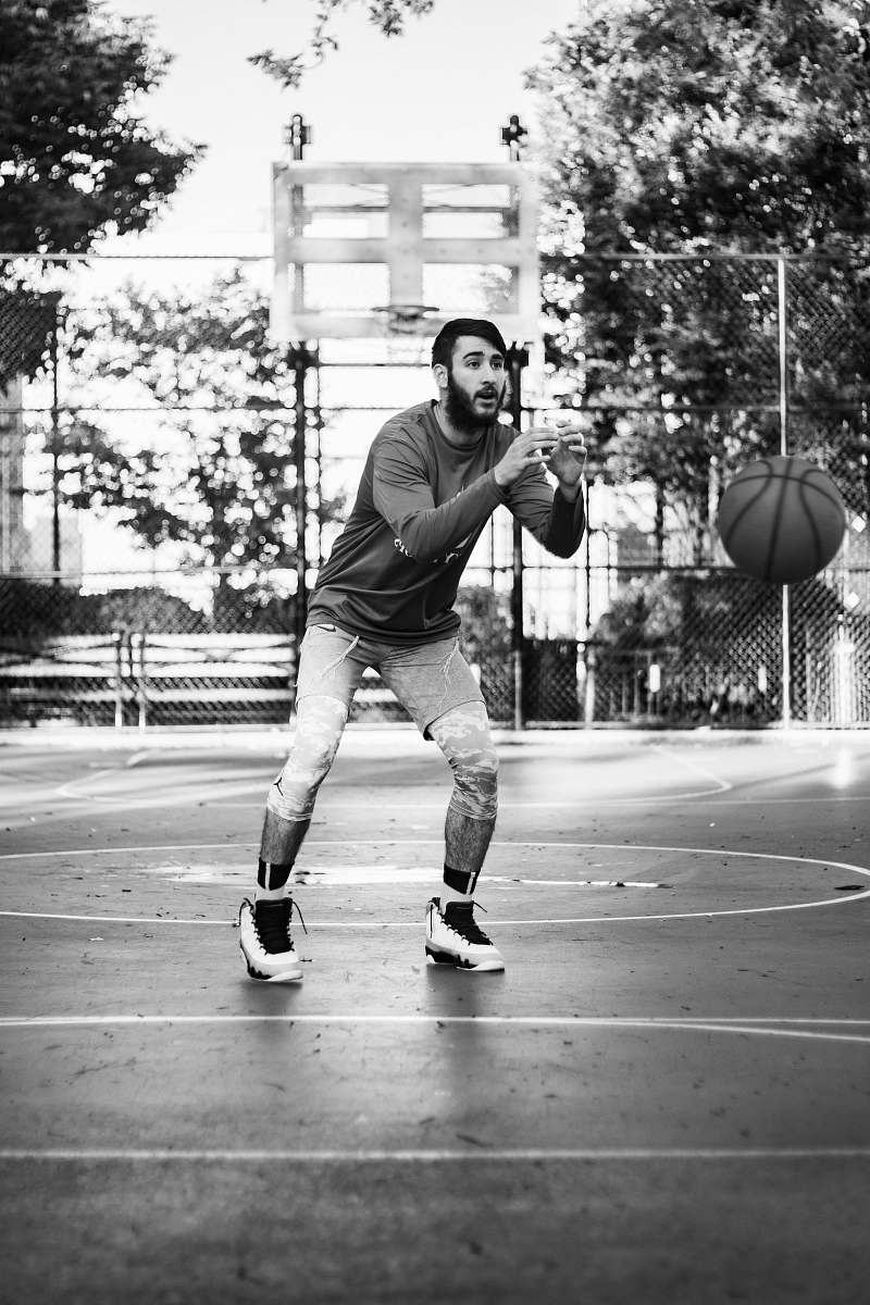 human man playing basketball and about to catch the ball black-and-white