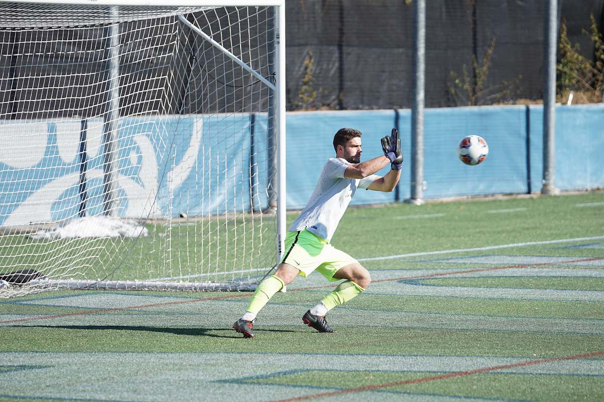 human man playing soccer during daytime football
