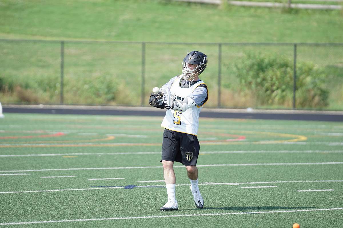 human man wearing white jersey playing on grass field people