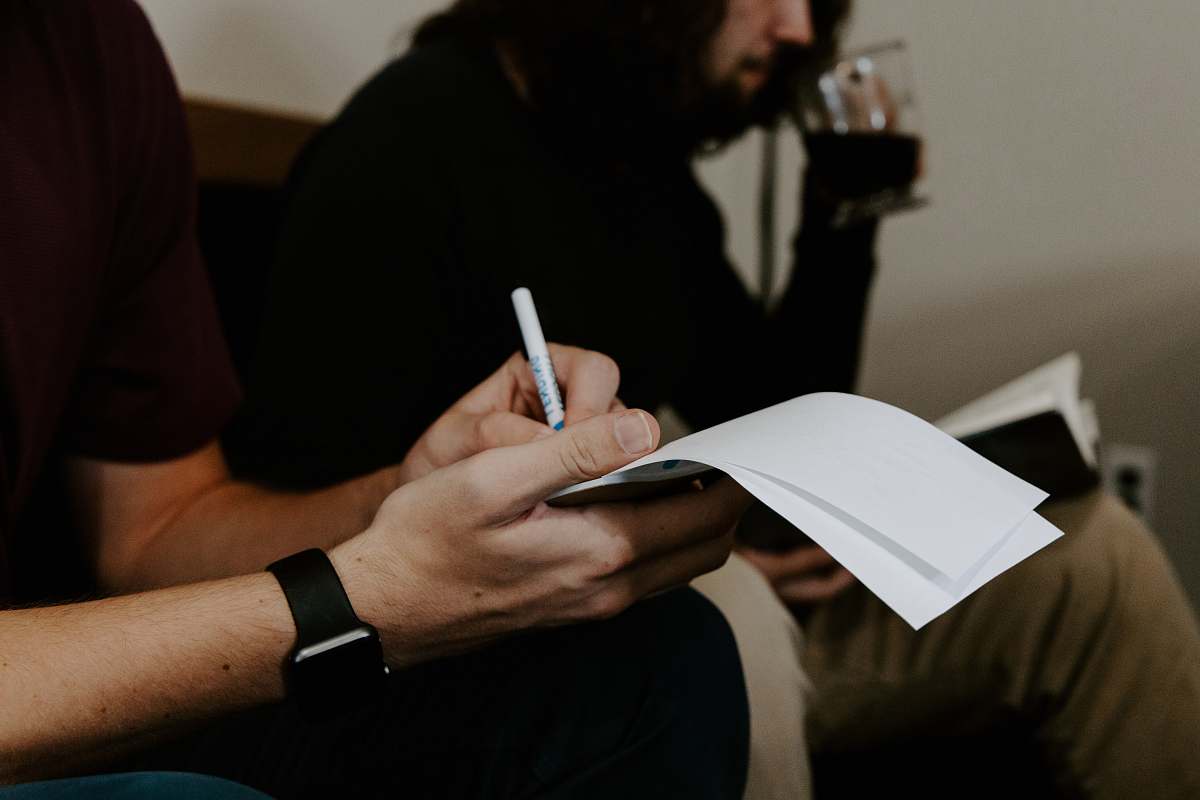 human man writing beside man people