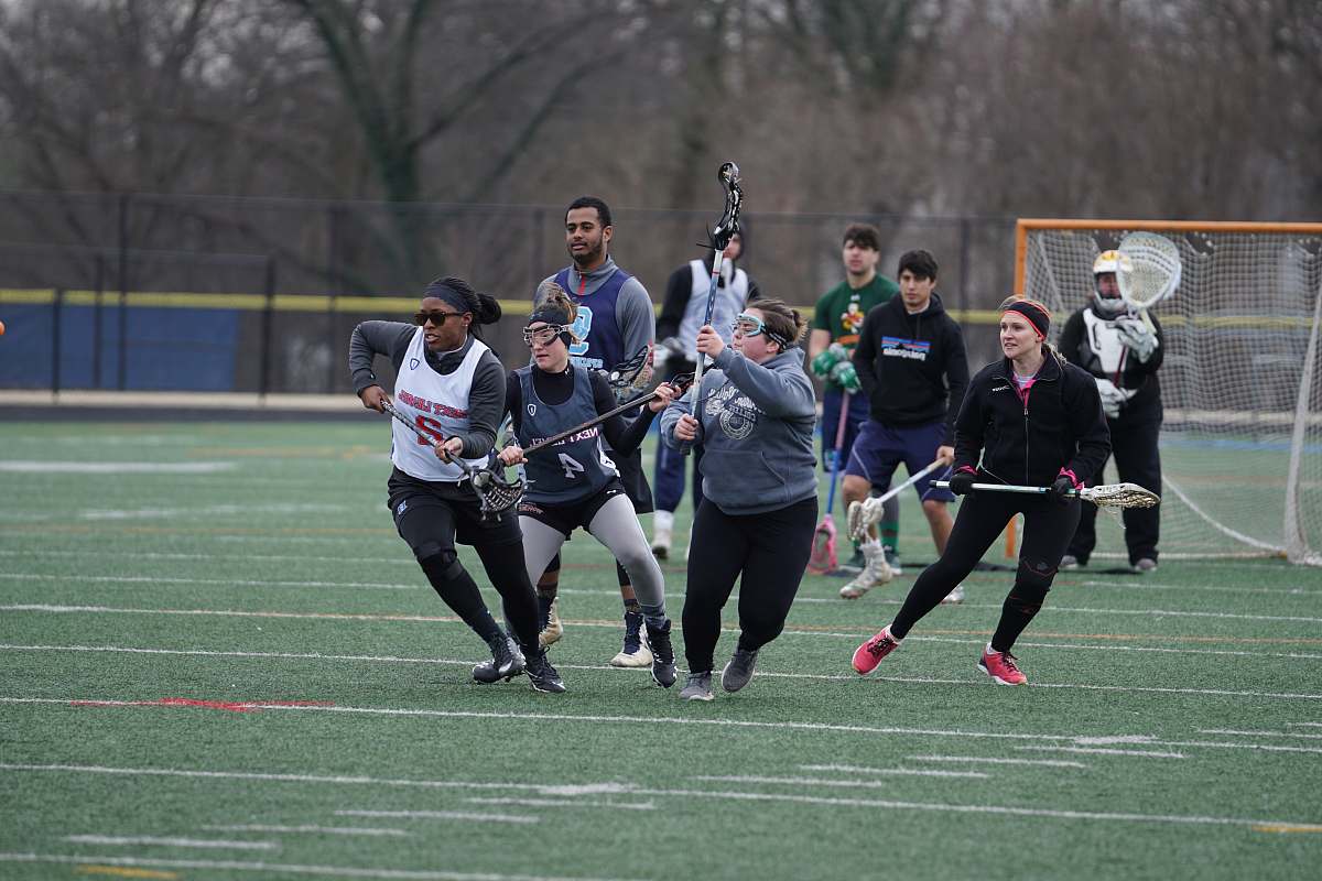 human men and women playing lacrosse sport during daytime apparel