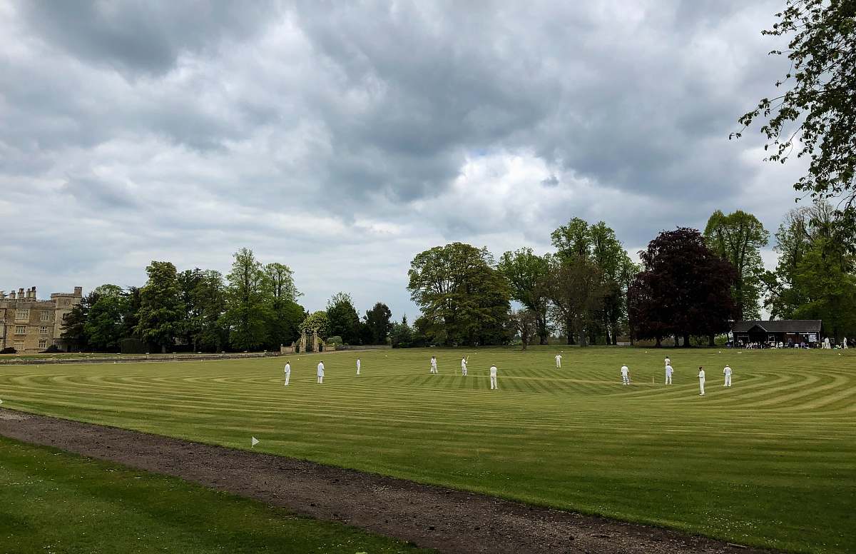 human men on grassy plain field under heavy clouds field