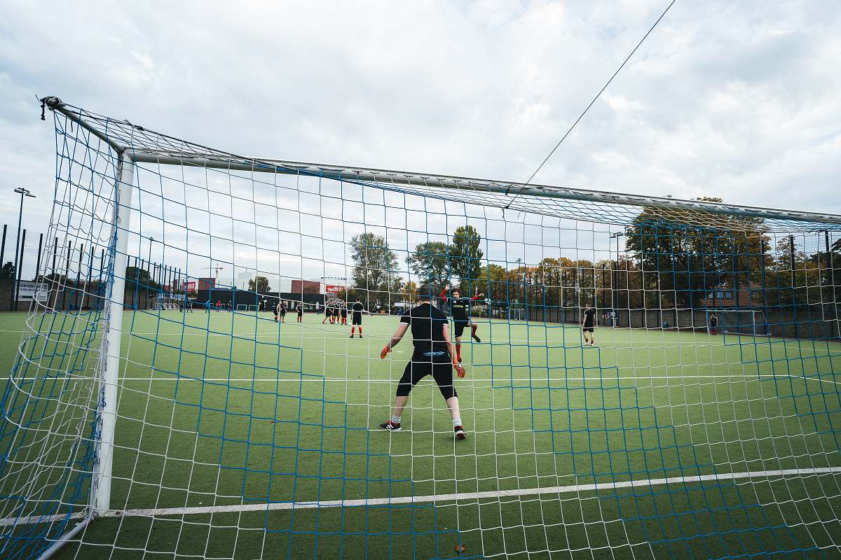 human men playing soccer on field people