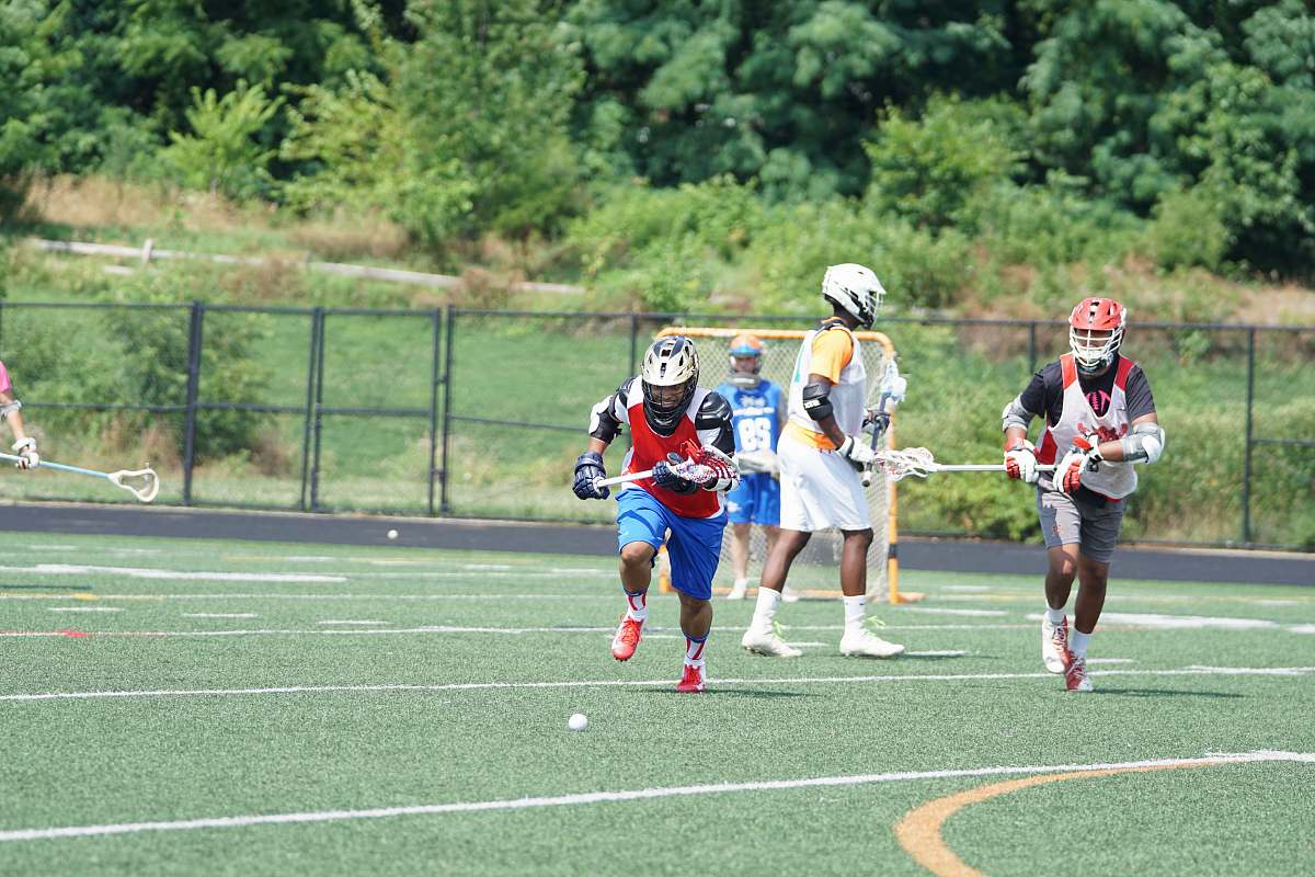 human people playing lacrosse during daytime field