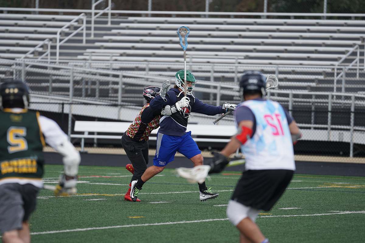 human people playing lacrosse game in field apparel