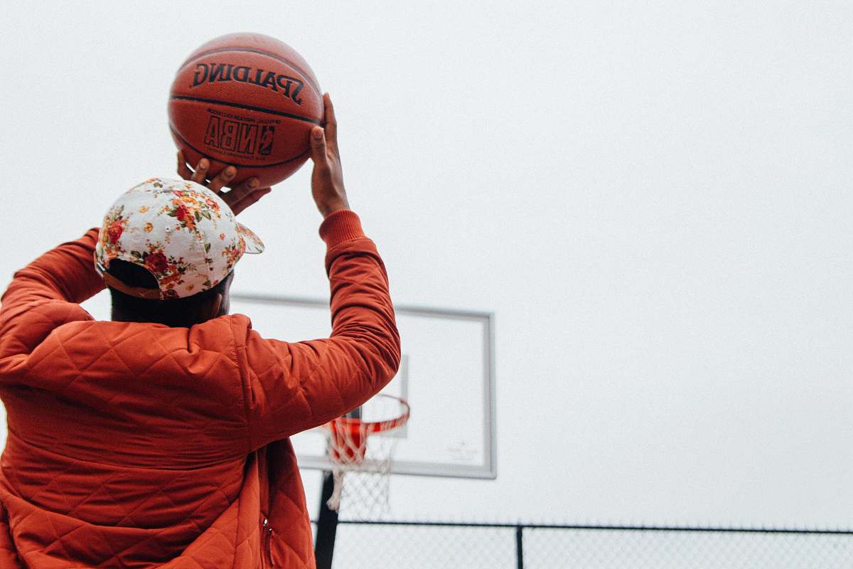 sport person holding basketball looking at basketball hoop system people