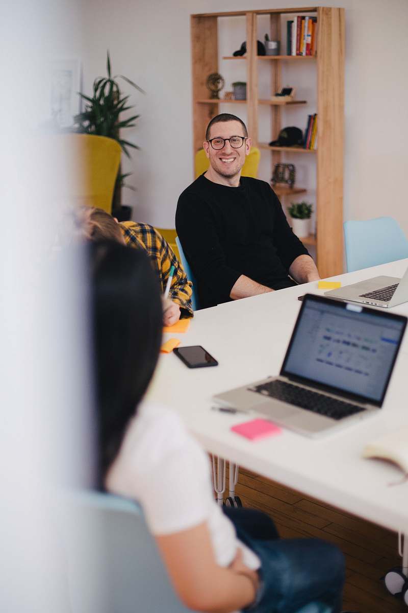 human smiling man beside writing person furniture