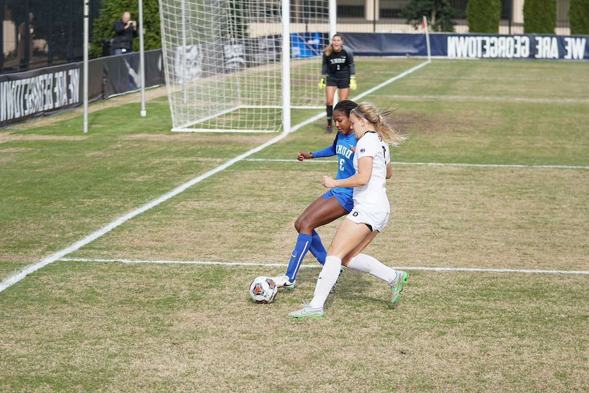 human two girls playing soccer during daytime people
