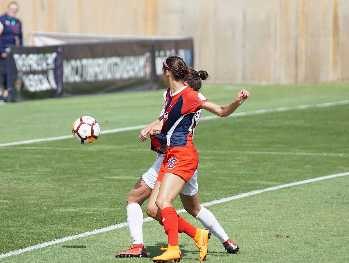 human two women soccer player standing on soccer field at daytime soccer