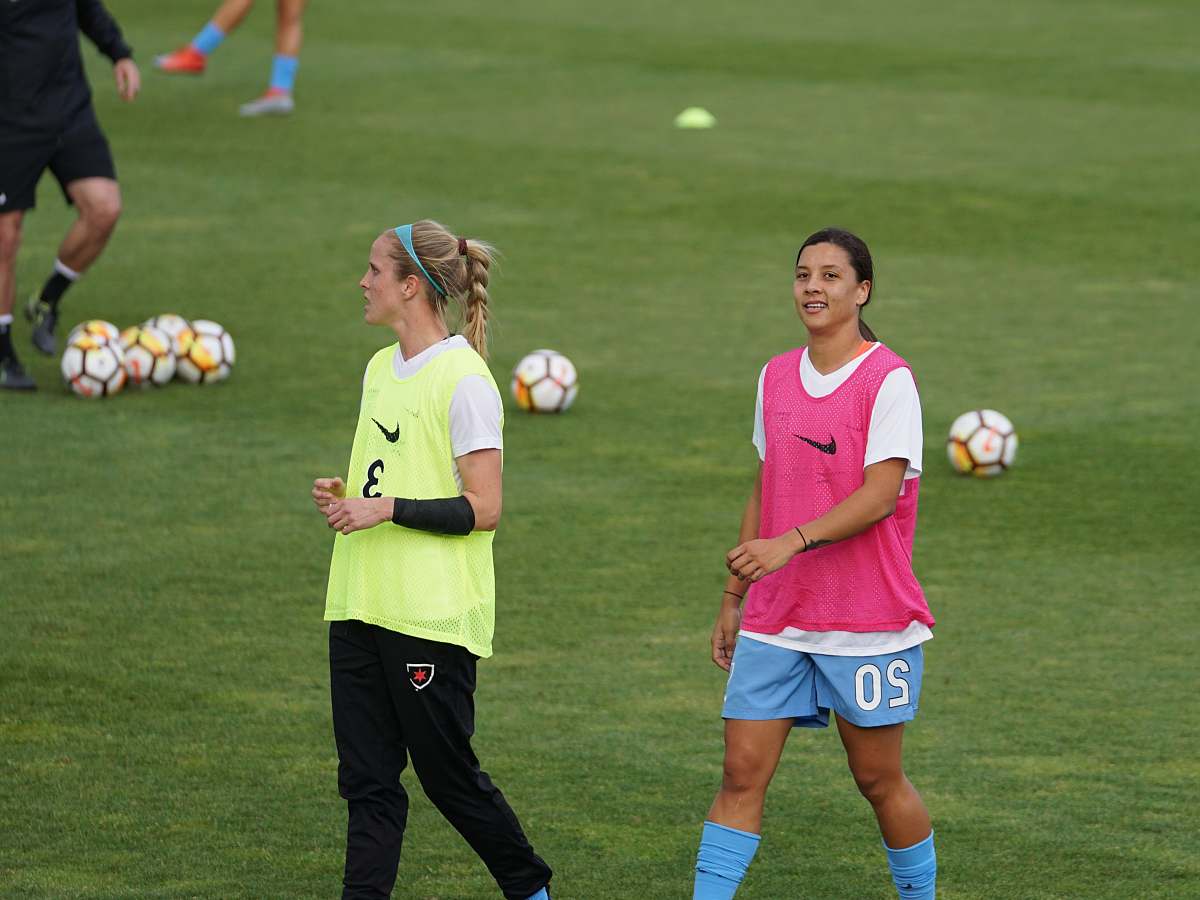 football two women wearing pink and yellow Nike tank tops soccer
