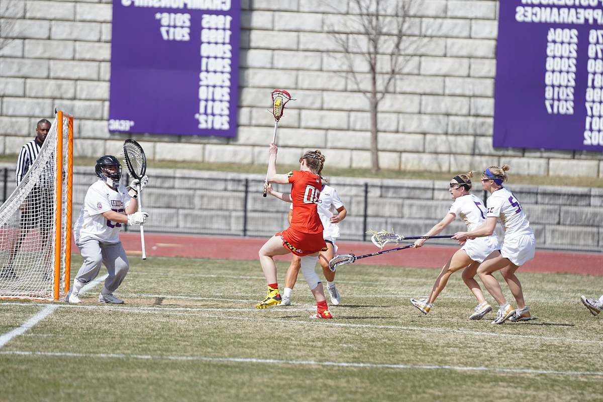 human women playing lacrosse at the field hockey