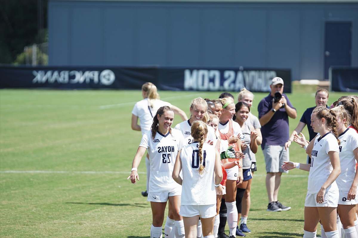 human women standing on soccer field people