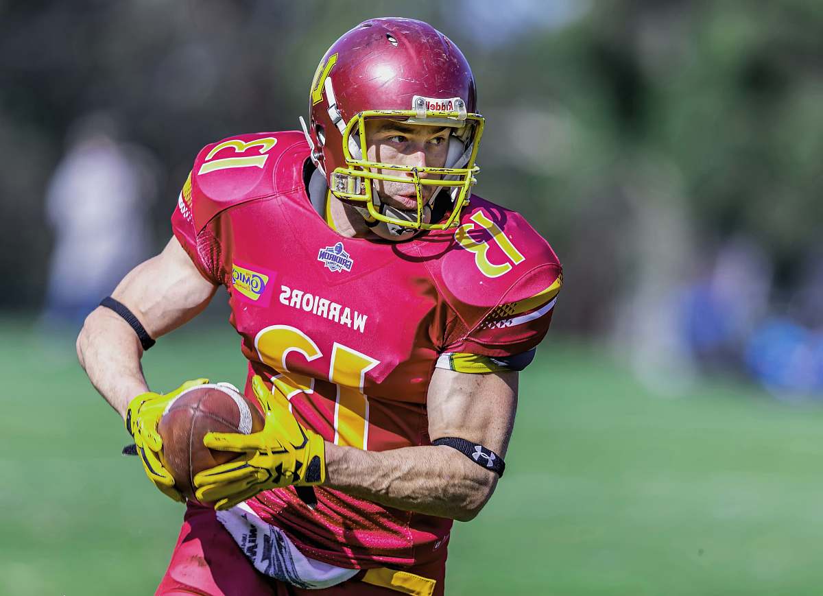sports American football player holding American football in field football