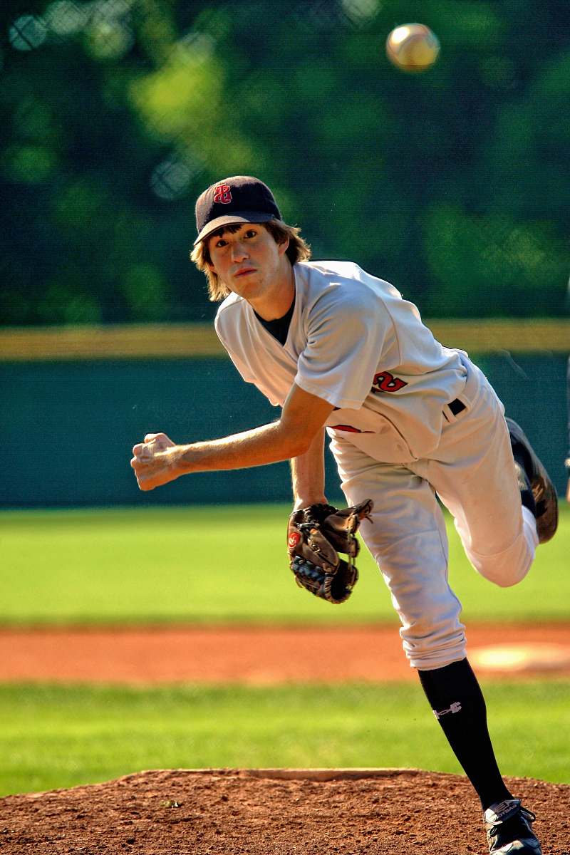 team baseball pitcher throwing some fast ball pitch baseball
