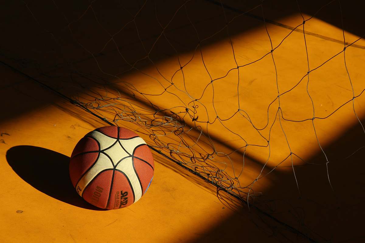 ball basketball near broken chain fence in dim light sphere