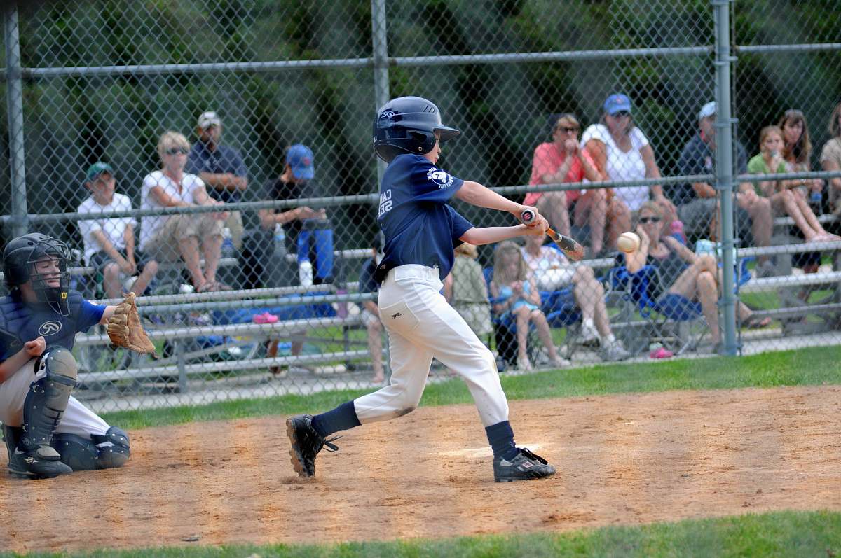 sports boy batting baseball near catcher beside gray fence baseball