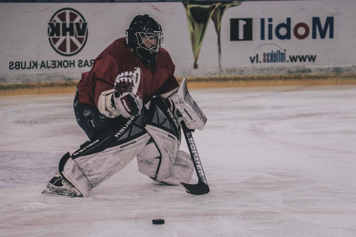 hockey ice hockey player on court playing near mobil 1 and VHK painted wall ice hockey
