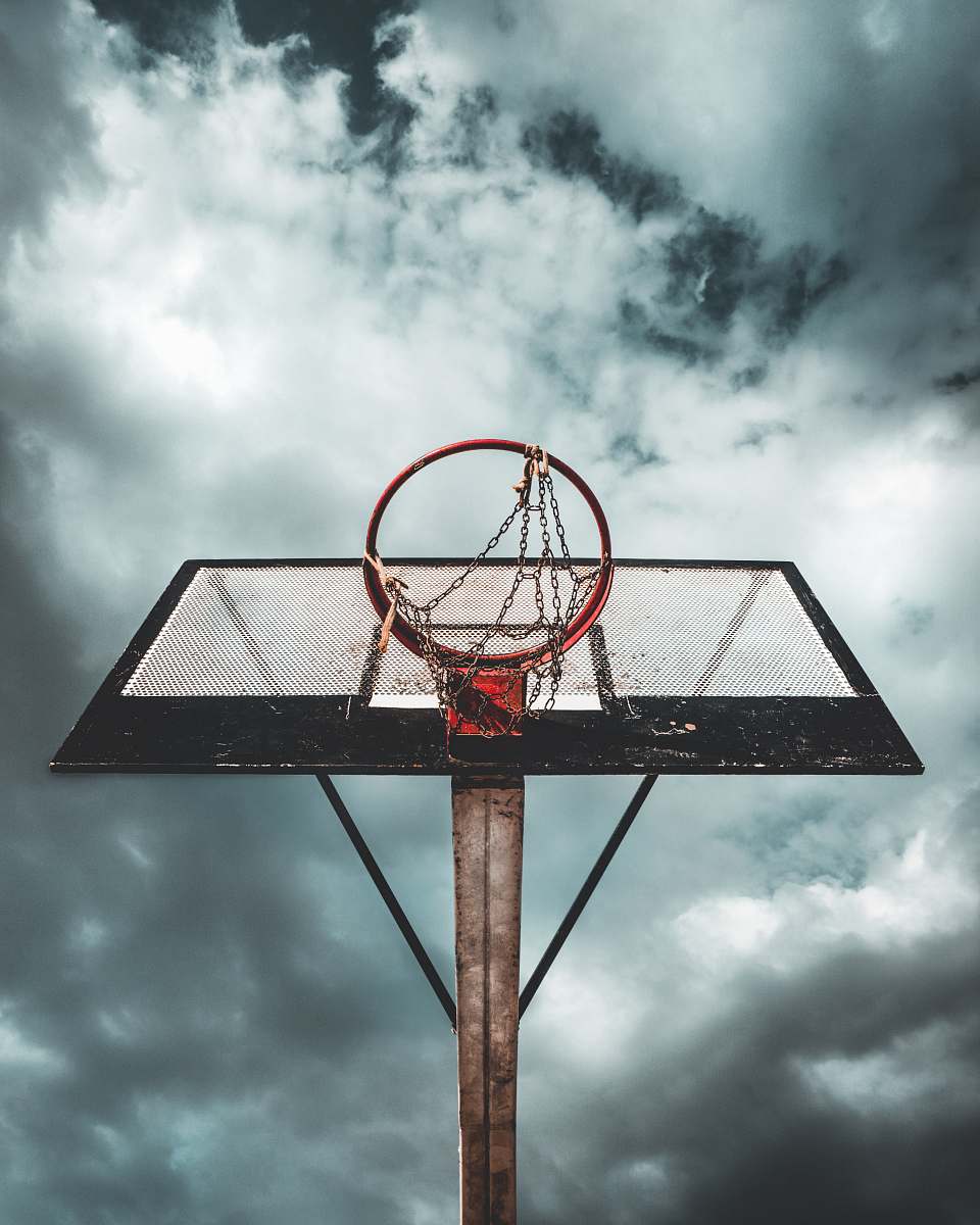 basketball low angle photo of white and black metal portable basketball hoop under cloudy sky during daytime sports