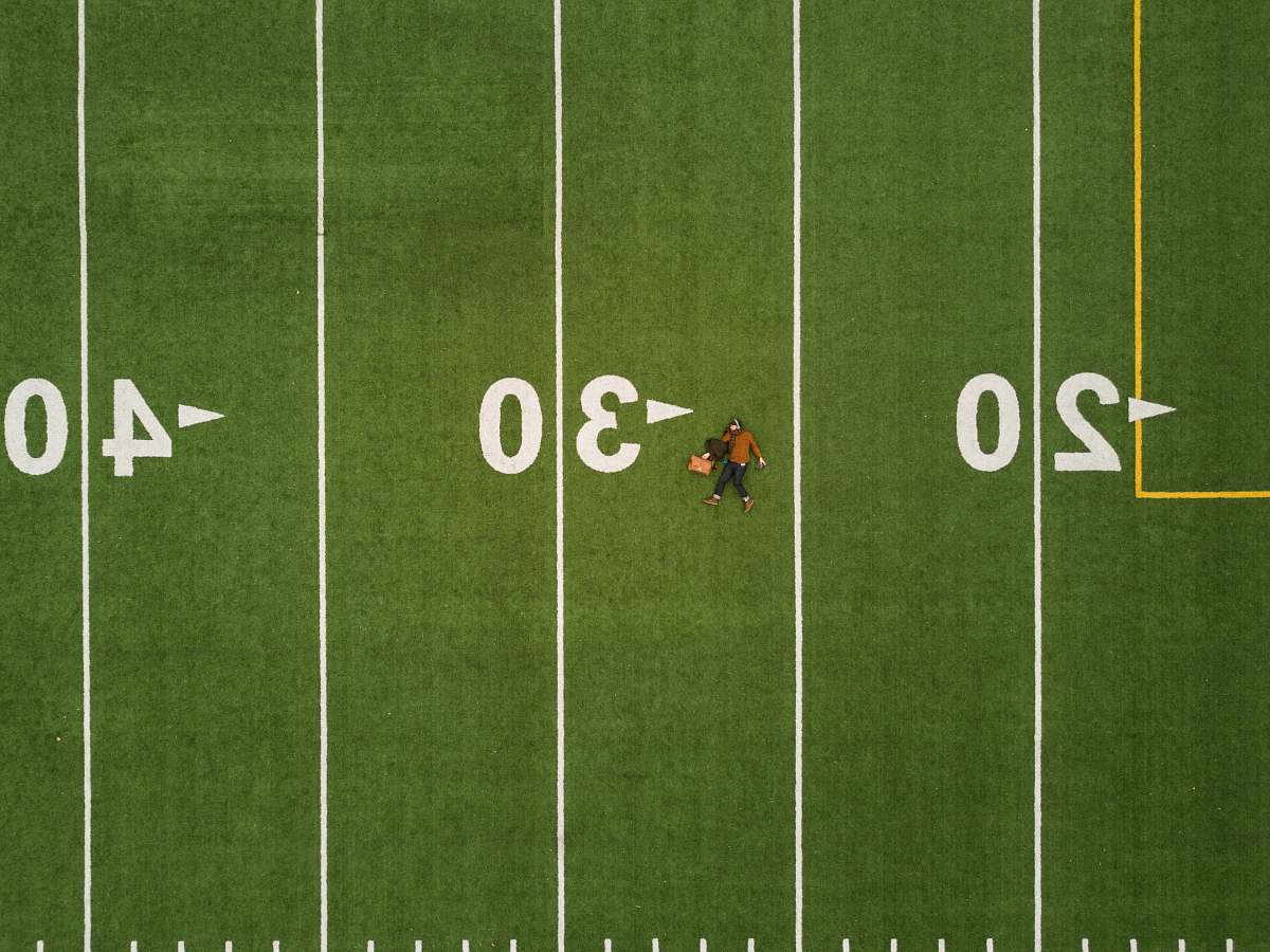 person man lying on 30 yards on football field football