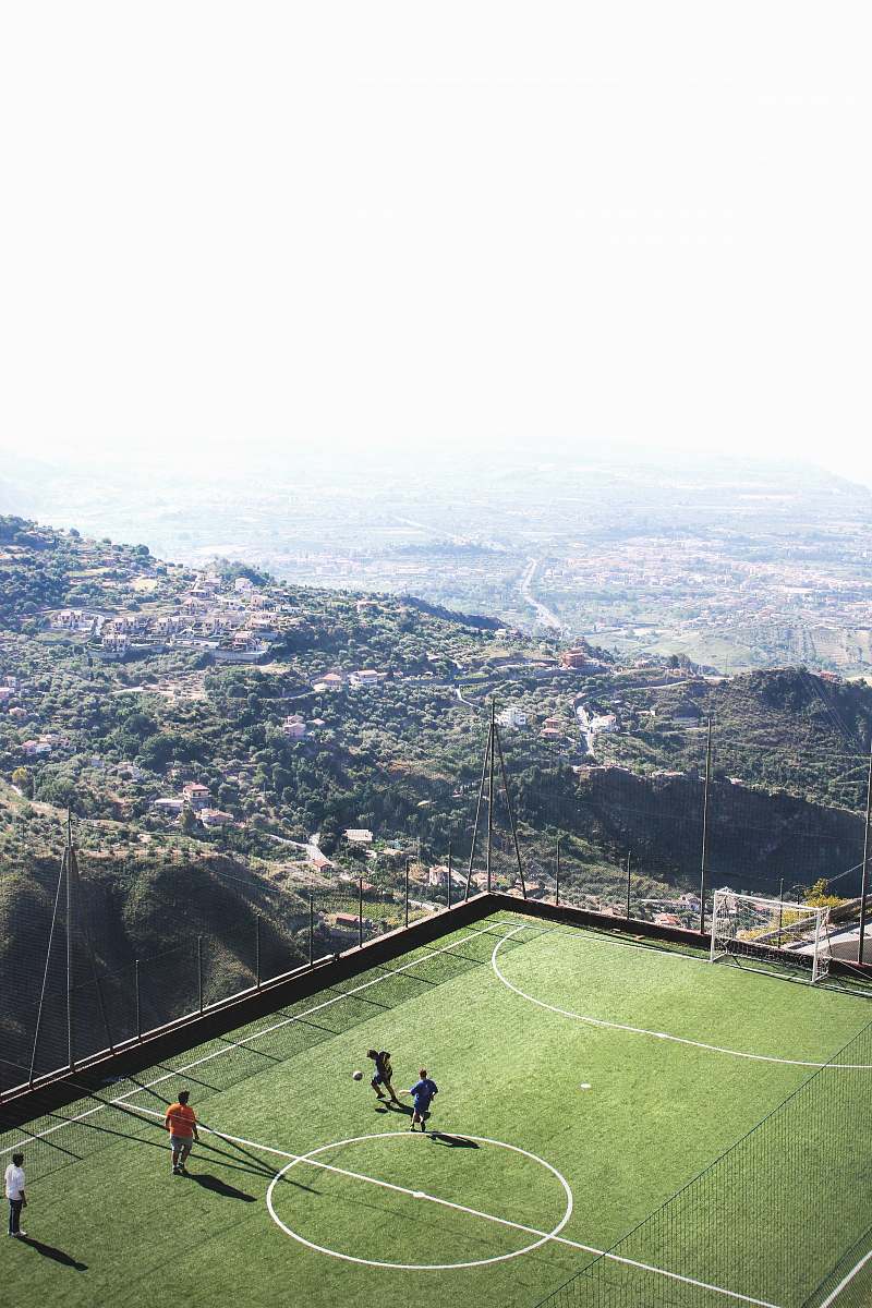 football men playing soccer during daytime italy
